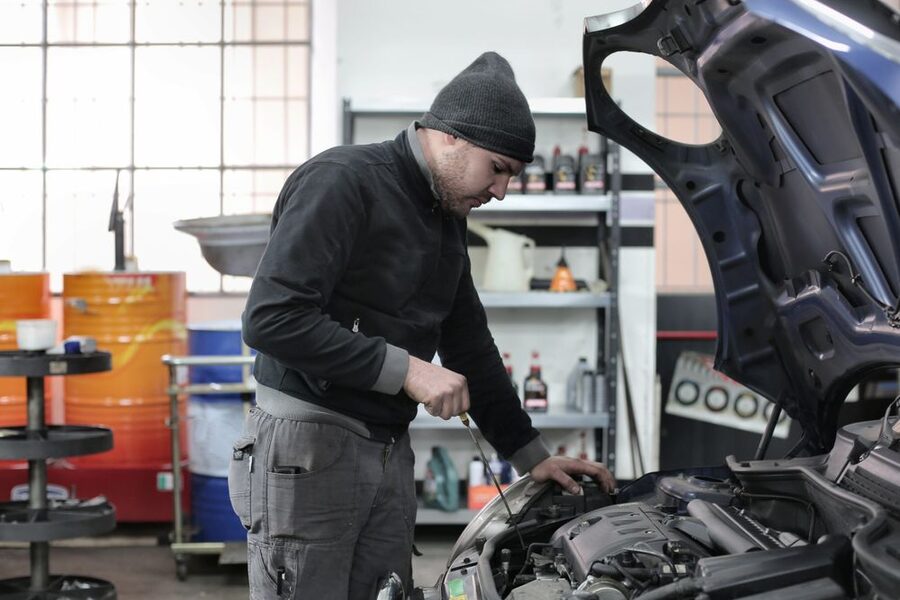 An auto technician working under the hood